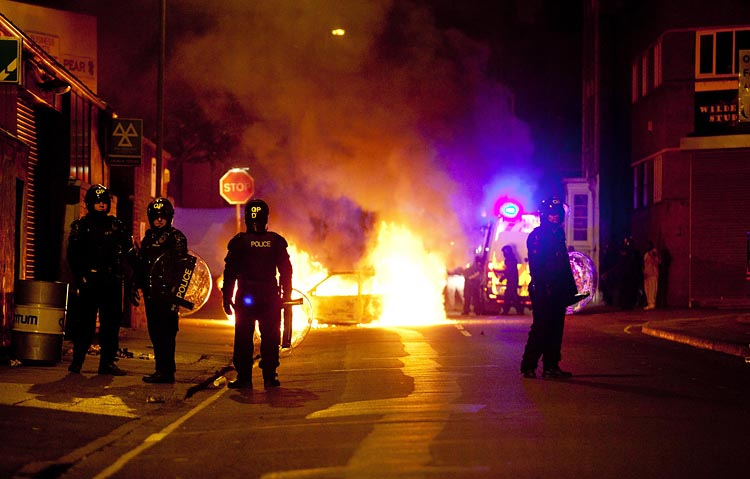 Riot police stand by a burning car in Bristol / Adam Gasson / adamgasson.com