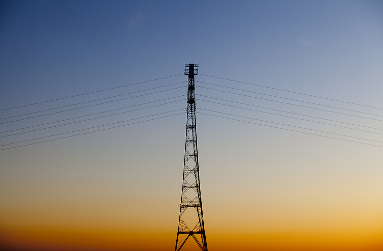 An electricity pylon crossing the River Severn at sunset by Adam Gasson