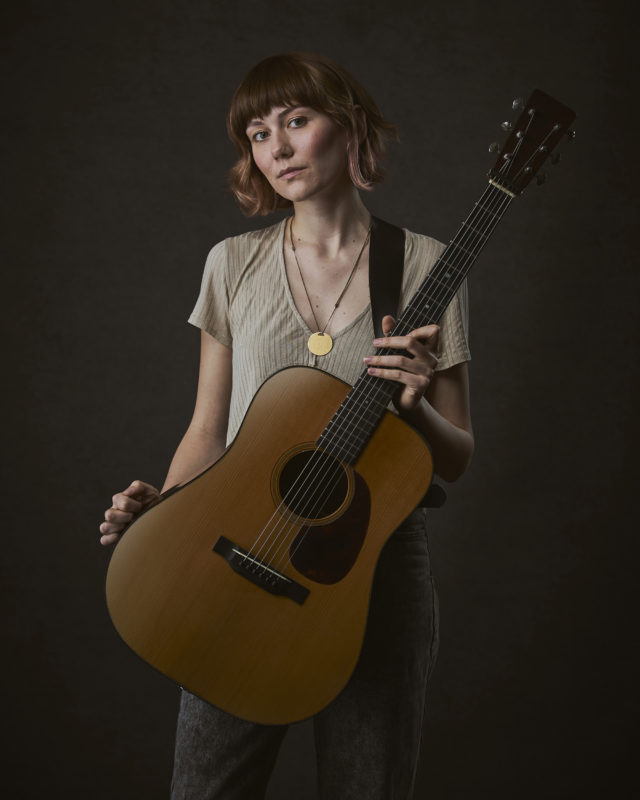 Molly Tuttle portrait photograph with an acoustic guitar