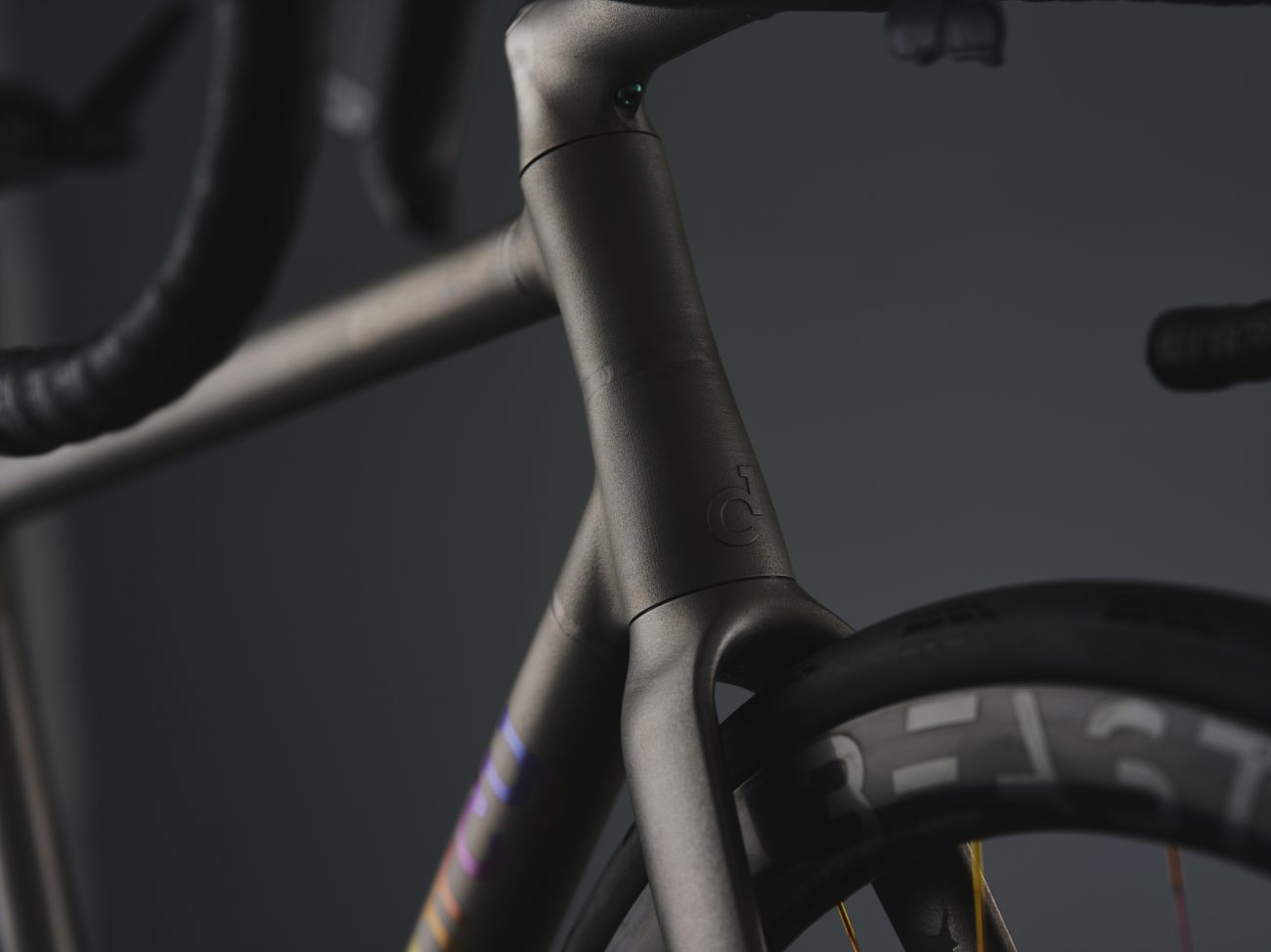 Studio photo of a Sturdy Cycles titanium 3D printed road bike floating on a small strip of tarmac