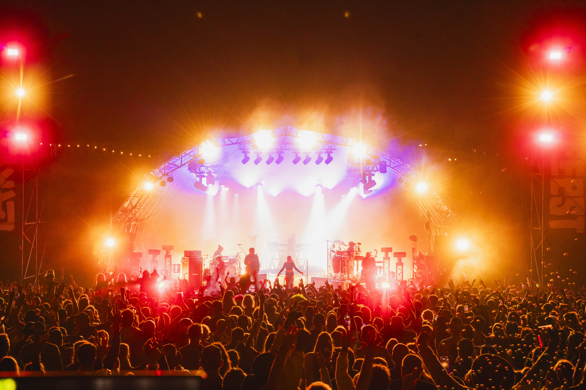 Wide angle photograph showing the stage and crowd of the band Faithless performing at Lakefest in 2025
