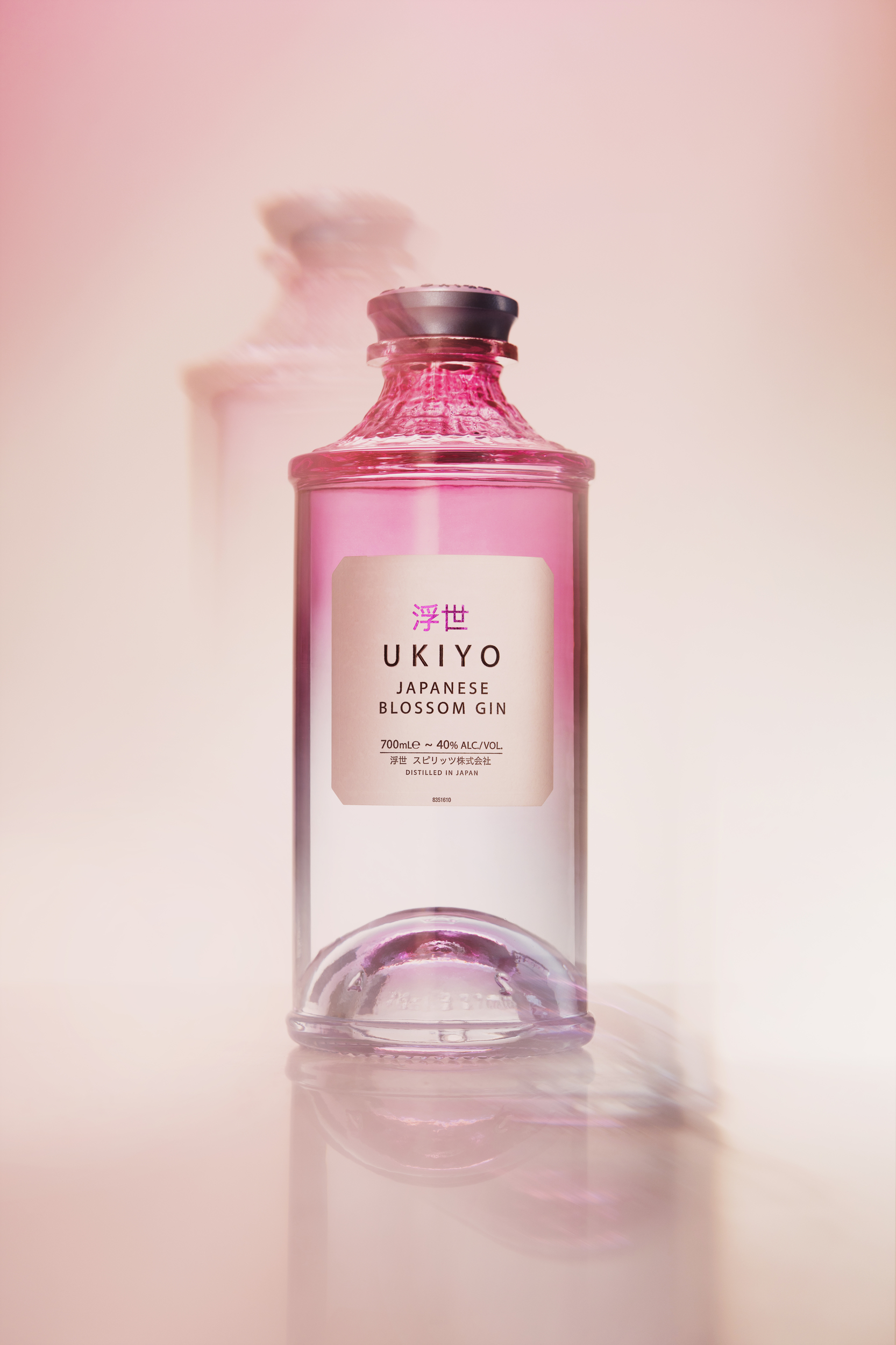 Studio photograph of Ukiyo Blossom Gin on a pink and orange gradient background